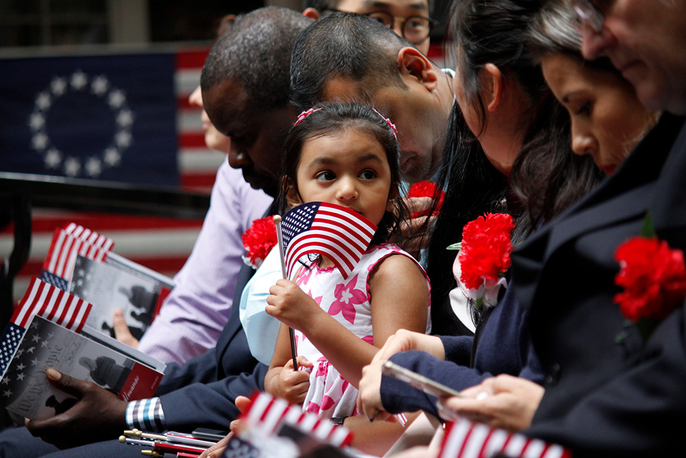 girl waves flag at naturalization ceremony