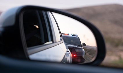 image of car with police car in review mirror