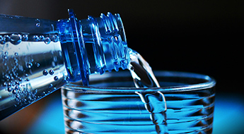 image of bottled water being poured into a glass