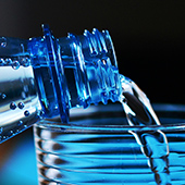 image of bottled water being poured into a glass