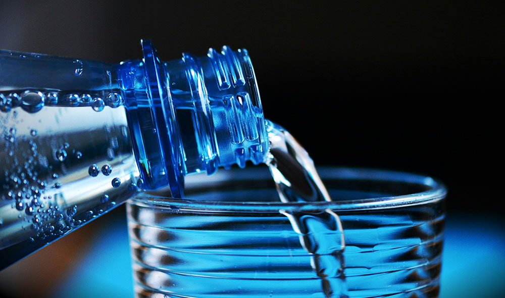 image of bottled water being poured into a glass