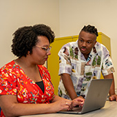 Two researchers look at a laptop together